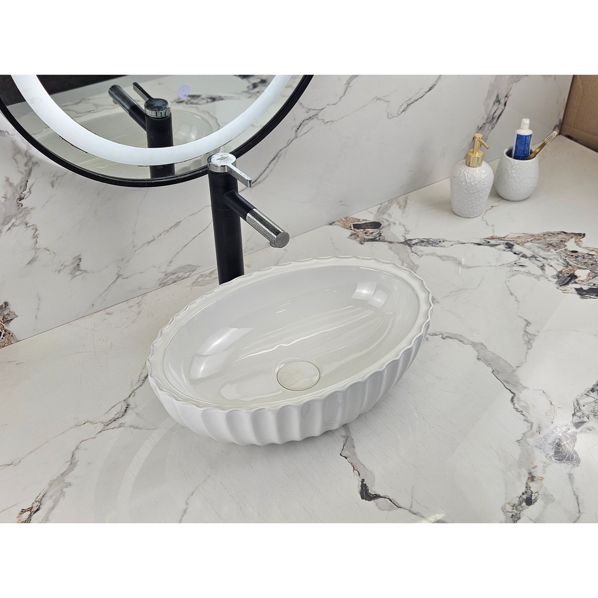 Infinity IA102 oval fluted gloss white basin installed on a marble vanity, angled view
