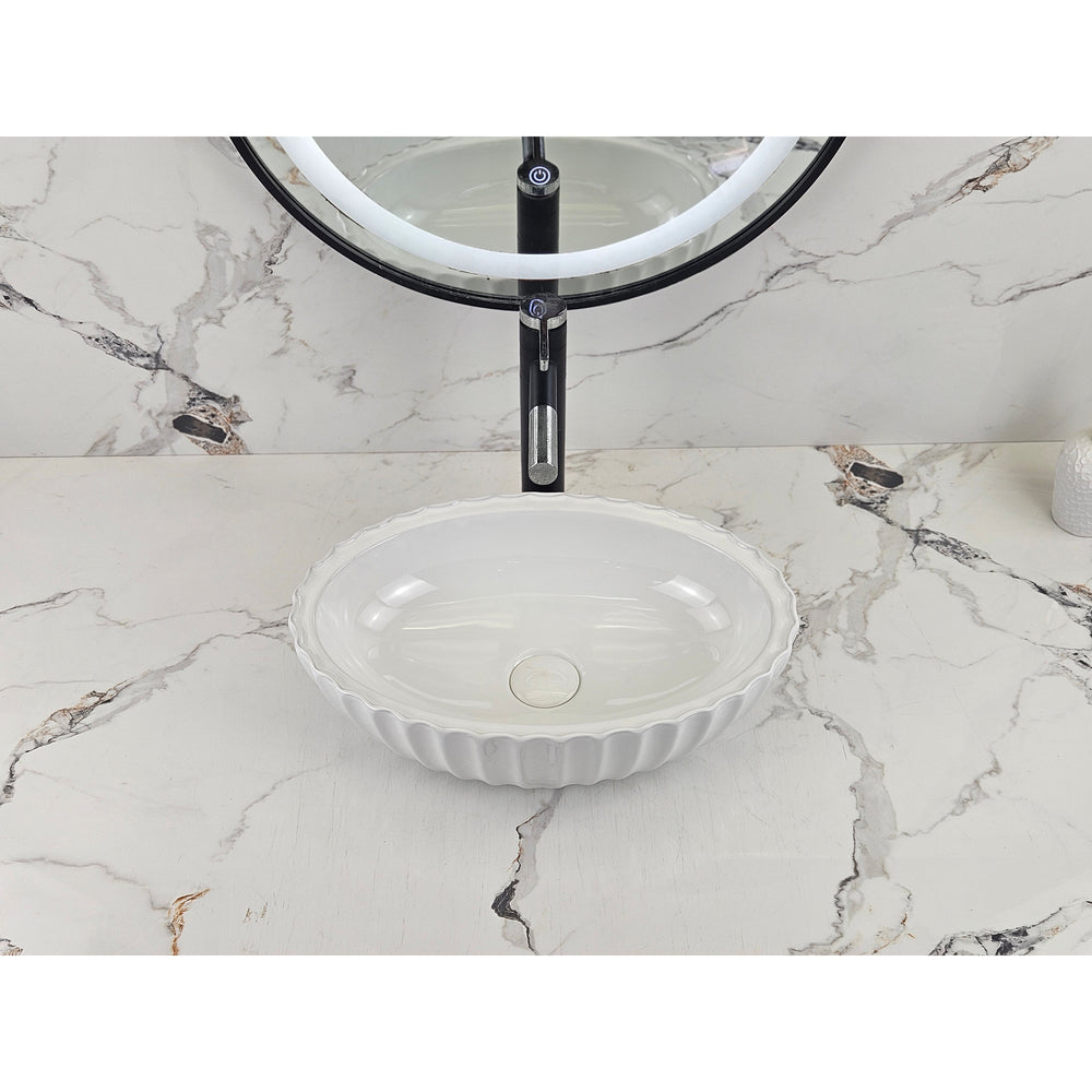 Infinity IA102 oval fluted gloss white basin shown front-on with black tapware